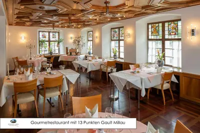 a dining room with tables and chairs and windows at Hotel de Charme Römerhof in Arbon