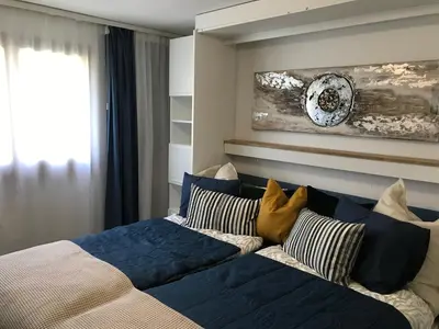 a bedroom with a bed with blue sheets and pillows at Sonnastuba in Wildhaus