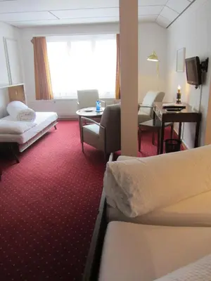 a hotel room with two beds and a desk at Landhaus an der Thur in Alt Sankt Johann