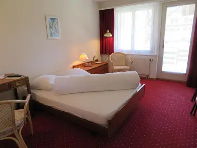 a hotel room with two beds and a desk and window at Landhaus an der Thur in Alt Sankt Johann