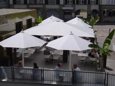 a group of white umbrellas at a restaurant at Herisau Swiss Quality Hotel in Herisau