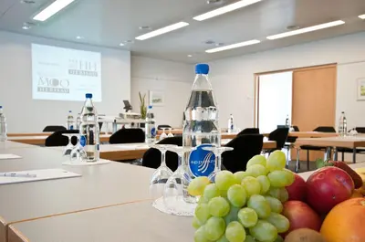a bottle of water and a bunch of fruit on a table at Herisau Swiss Quality Hotel in Herisau