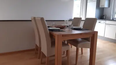 a dining room table with chairs and a table with wine glasses at Attika Ferienwohnung Merk in Kreuzlingen