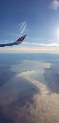 a wing of an airplane flying over a body of water at Attika Ferienwohnung Merk in Kreuzlingen