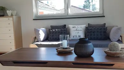 a living room with a table and a couch at Attika Ferienwohnung Merk in Kreuzlingen