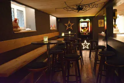 a bar with a bunch of stools in a room at Gasthaus Sternen in Degersheim
