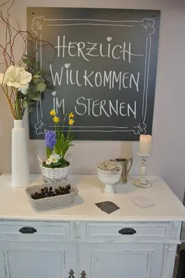 a white dresser with flowers and a chalkboard at Gasthaus Sternen in Degersheim