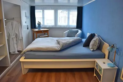 a bedroom with a bed with a blue wall at Gasthaus Sternen in Degersheim
