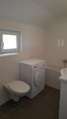 a white bathroom with a toilet and a sink at London Apartments in Rheineck