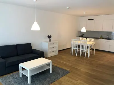 a living room with a couch and a table and a kitchen at Giesserei in Arbon