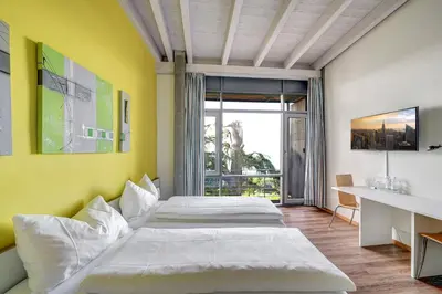 a bedroom with two beds and a yellow wall at Schloss Wartensee in Rorschacherberg