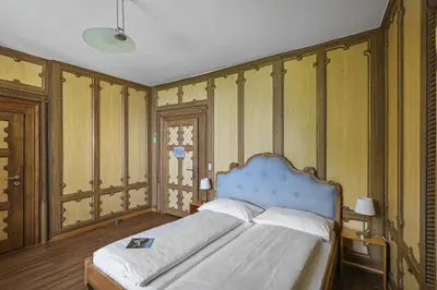 a bedroom with a blue bed with wooden walls at Schloss Wartensee in Rorschacherberg
