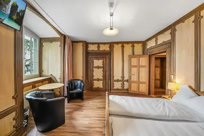 a bedroom with a bed and a desk and a table at Schloss Wartensee in Rorschacherberg