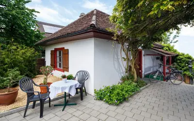 a table and chairs in front of a small house at Historische Residenz Lindeneck in Güttingen