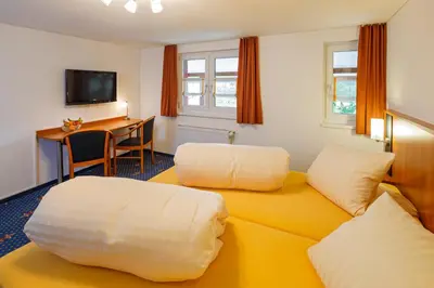 a hotel room with a yellow couch and a desk at Historische Residenz Lindeneck in Güttingen