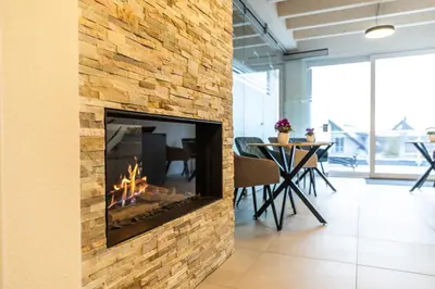 a stone fireplace in a room with a table at Historische Residenz Lindeneck in Güttingen
