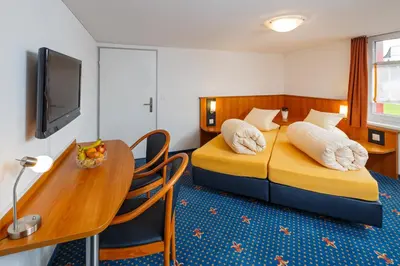 a hotel room with two beds and a table at Historische Residenz Lindeneck in Güttingen