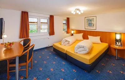 a hotel room with a bed and a table at Historische Residenz Lindeneck in Güttingen