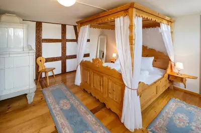 a bedroom with a wooden bed with a canopy at Historische Residenz Lindeneck in Güttingen