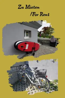 a bike parked next to a house with a surfboard at Studio direkt am Bodensee in Thal