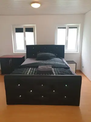 a large black bed in a room with windows at 3 Doppel Zimmer Apartement in 9320 Arbon in Arbon
