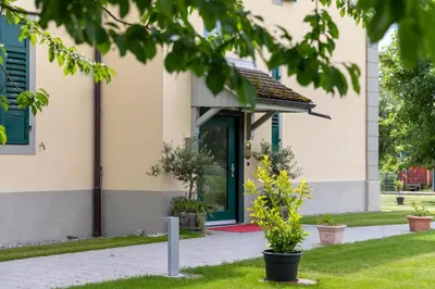 a building with a green door and plants at VILLA TAEGERMOOS in Tägerwilen