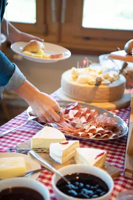 a table with cheese and other foods on it at Restaurant und Kaeserei Berghof in Ganterschwil