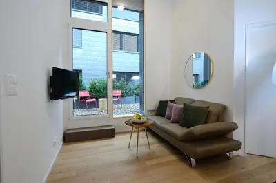 a living room with a couch and a mirror at Hotel Profis in Diepoldsau