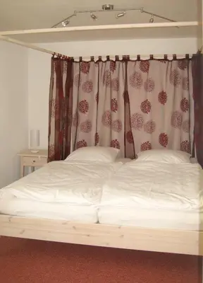 a bedroom with a bed with a canopy at Gästehaus am Sonnenfeld in Sommeri