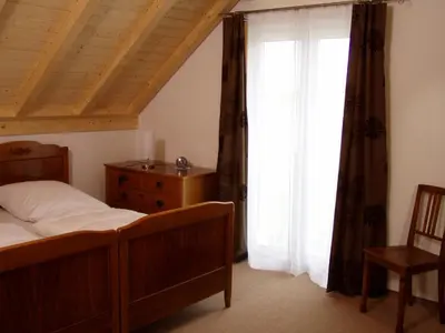 a bedroom with a bed and a dresser and a window at Gästehaus am Sonnenfeld in Sommeri