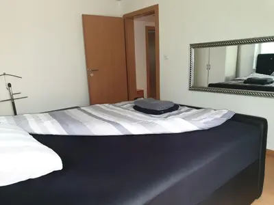 a bed in a room with a mirror at 3 Doppelbett Business Apartment am Bodensee in Arbon