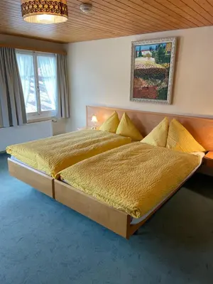 a bedroom with a large bed with yellow blankets and pillows at Landgasthof Schäfle in Sankt Peterzell