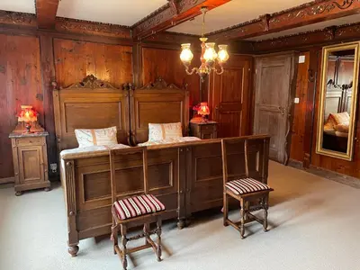 a bedroom with a bed and two stools at Landgasthof Schäfle in Sankt Peterzell