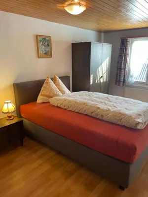 a bedroom with a large bed with a red blanket at Landgasthof Schäfle in Sankt Peterzell