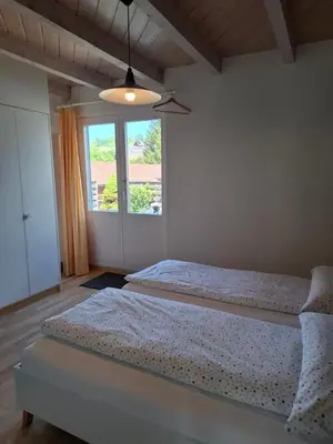 two beds in a room with a window at Zwinglis Ferienwohnung in Nesslau