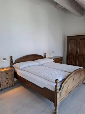 a bedroom with a wooden bed and a wooden dresser at Zwinglis Ferienwohnung in Nesslau