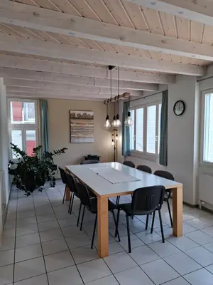 a dining room with a large wooden table and chairs at Zwinglis Ferienwohnung in Nesslau
