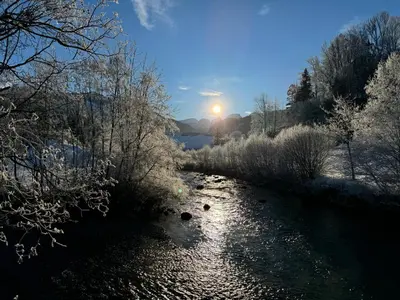 a river with the sun setting in the background at Zwinglis Ferienwohnung Klärli in Nesslau