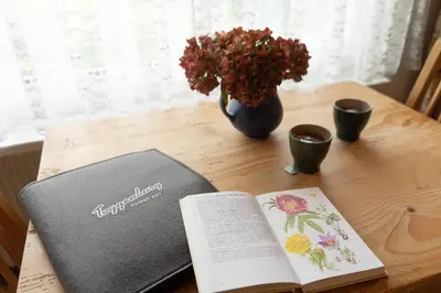 a book and a vase of flowers on a table at Jambo Pua in Alt Sankt Johann