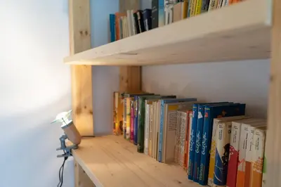 a row of books on a book shelf at Jambo Pua in Alt Sankt Johann