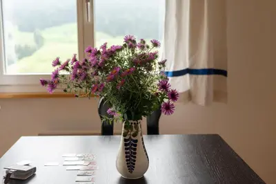 a vase filled with purple flowers sitting on a table at Sonnhalde in Wildhaus