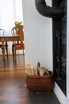 a basket sitting next to a fireplace in a living room at Sonnhalde in Wildhaus