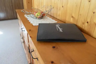 a wooden table with a black notebook on top of it at Frühweid in Unterwasser