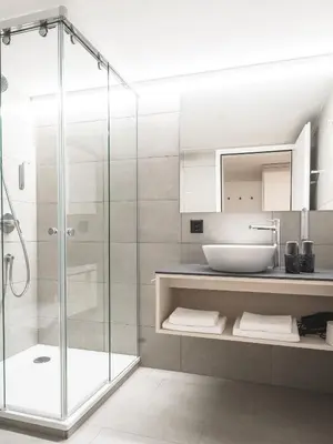 a bathroom with a glass shower and a sink at Traube Restaurant & Hotel in Appenzell