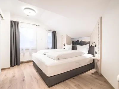a bedroom with two white beds and a large window at Traube Restaurant & Hotel in Appenzell