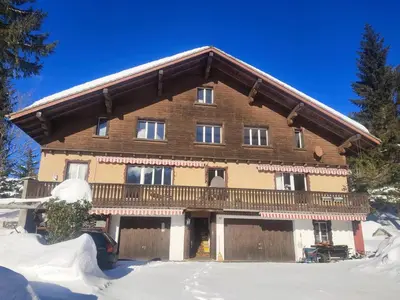 a large wooden house with a balcony in the snow at Säntisecho - in der Natur zu Hause in Urnäsch