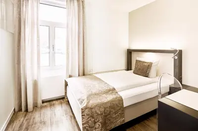 a bedroom with a bed and a large window at Hotel Schäfli in Uzwil