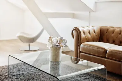 a living room with a glass table and a couch at Hotel Schäfli in Uzwil