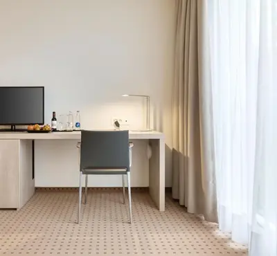 a desk with a chair and a computer monitor at Hotel Eastside (free parking garage) in St. Gallen