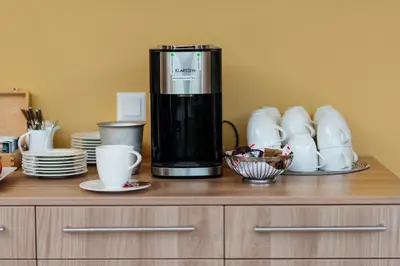 a coffee maker sitting on top of a wooden cabinet at Hotel Restaurant Sokrates in Güttingen